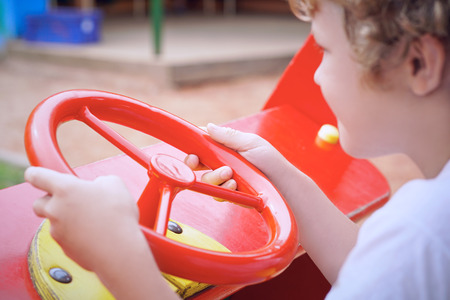Cute toddler boy having fun on playground. Active outdoors game for little childrenの写真素材
