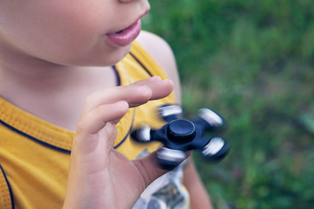 Happy smiling child playing with Spinner. Photo with depth of field.の写真素材