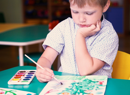 Llittle cute boy drawing with colorful watercolors. School, education concept.の写真素材