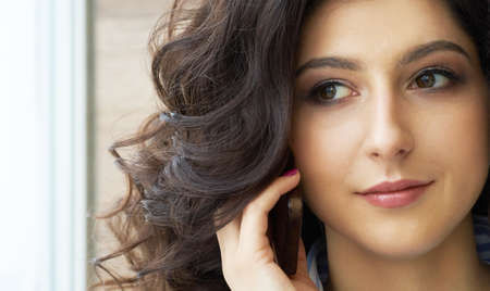 Girl with long curly hair. Perfect skin. Stylish gorgeous girl in the luxury beauty salon. Girl with...