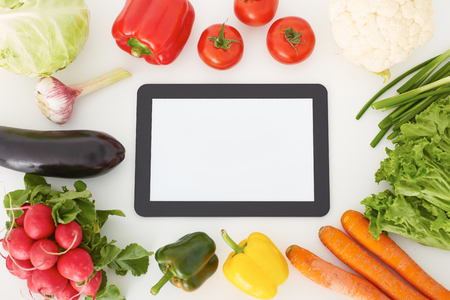 Blank touch screen digital tablet and fresh vegetables. Food and gardening app concept.の写真素材