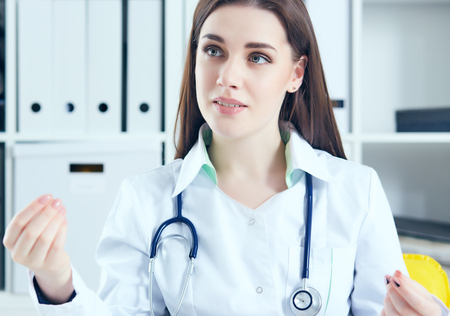 Young female doctor giving a consultation to a patient and explaining medical informations and diagnosisの写真素材