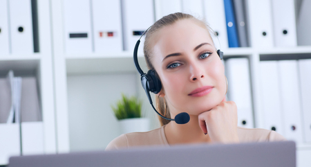 Close-up portrait of a customer service agent sitting at office.の写真素材