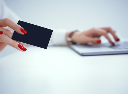 Close-up of womans hands holding a credit card at a computer keyboard. Convenient set of funds budget wallet deposit wealth and effective investment invest resources income profit conceptの写真素材