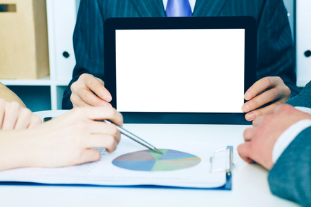 Business man showing digital tablet to coworkers in office. Teamwork concept.の写真素材