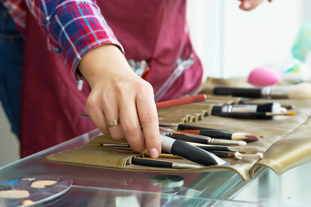 Close-up image of make-up artist hand choosing brush from the set.の写真素材