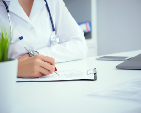 Close-up view of female doctor hands filling patient registration form. Healthcare and medical conceptの写真素材