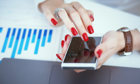 Businesswoman hand holds a new smartphone. The mobile application market shows a display you can insert your image for advertising or financial statistics.の写真素材