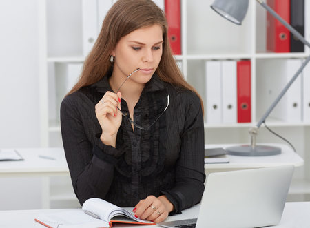 Young beautiful business woman looking at something on the desk. Business, analytics research, excellent education, certified public accountant concept.の写真素材