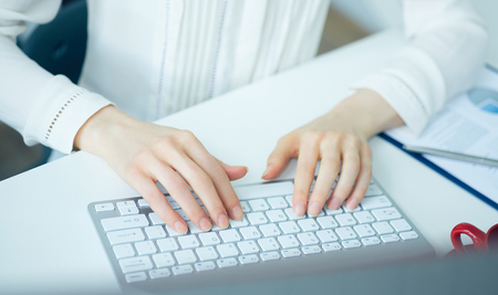 Female hands typing on desktop computer keyboard. Concept of freelance work.の写真素材