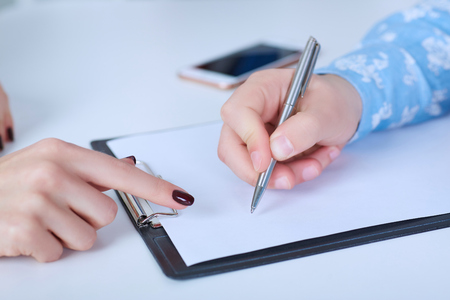 The employer forces the employee to write a letter of resignation. Just hands over the table.の写真素材