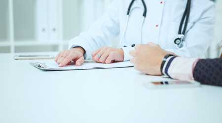 Female doctor talking to her female patient at office. Healthcare and medical concept.の写真素材