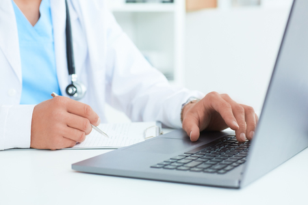 Male doctor, medical students or surgeon using laptop during the conference. Health Check with digital system support for patient, test results and data registration.の写真素材