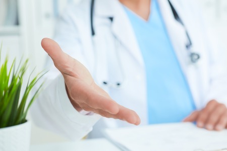 Friendly male doctor with open hand ready for hugging closeup.の写真素材