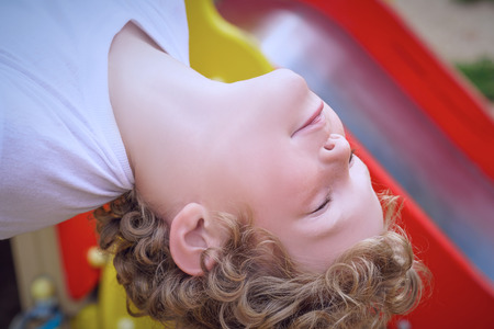 A young child having fun playing on equipment at a playground.の写真素材