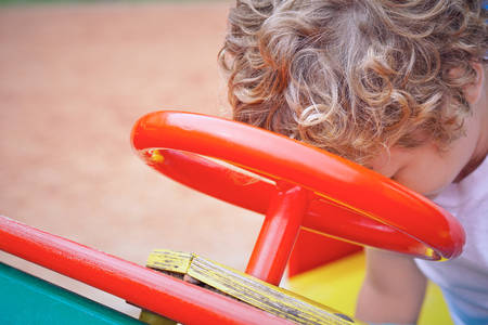 Cute toddler boy having fun on playground. Active outdoors game for little childrenの写真素材