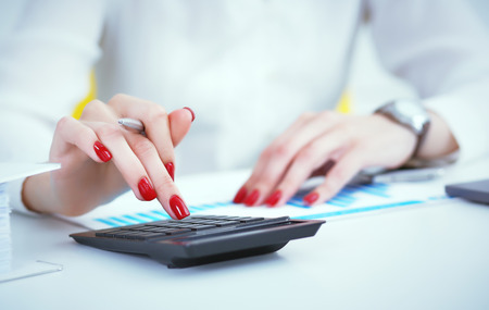 Close up hand of female accountant or banker making calculations. Savings, finances and economy conceptの写真素材