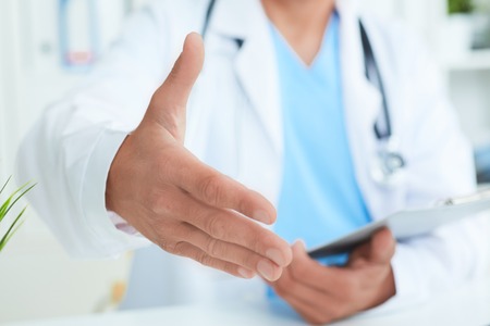 Friendly male doctor with open hand ready for hugging closeup.の写真素材