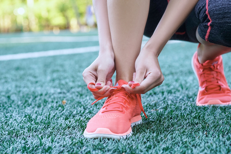 Healthy active woman athlete tying running shoes.の写真素材
