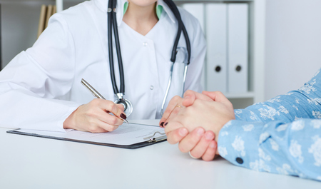 Doctor consulting patient closeup. Just hands over the table. Diagnostic, healthcare, medical service, consultation or education, healthy lifestyle conceptの写真素材