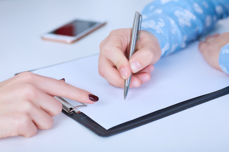 The employer forces the employee to write a letter of resignation. Just hands over the table.の写真素材