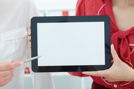 Tablet with empty space for text or picture closeup in business woman hands. Advertisement concept.の写真素材