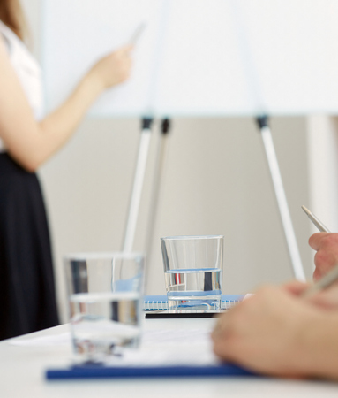 A glass of water in office workplace. The boardroom table is set for the Annual General Meeting. Water use for office workers. The concept of healthy eating in the workplace.の写真素材