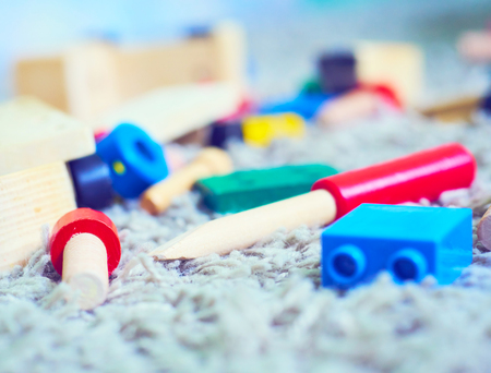 Plastic and wooden elements blocks for the designer lying on the carpet. Building kit is waiting for children.の写真素材