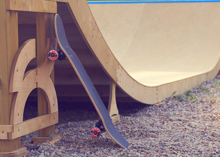 Skateboard standing on half pipe ramp at skatepark.の写真素材