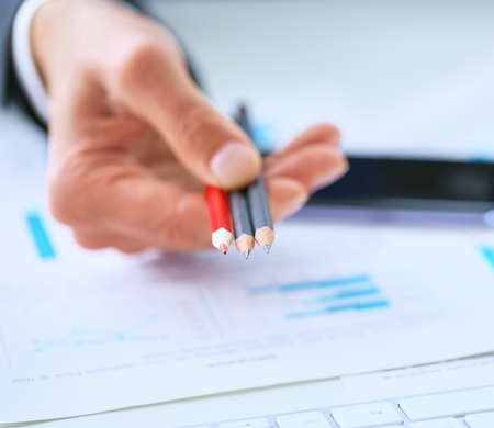 Businessman's hand giving color pencils that you can make notes in charts and tables.の写真素材
