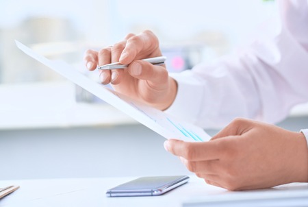 Serious business man working on documents and makes notes with aの写真素材