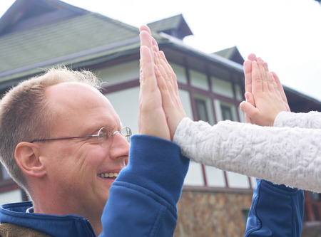 Father and daughter playing patty cake outdoors.の写真素材