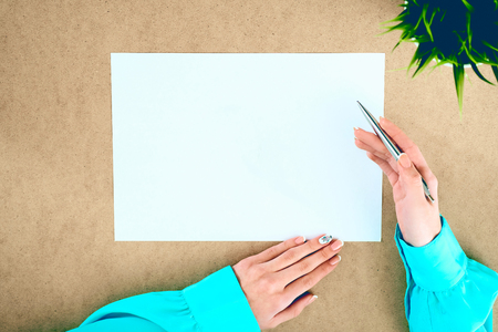 Blank paper lying on the table and waiting for idea with womans hands over it .の写真素材