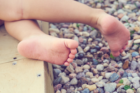 Babys feet of a small child close-up on the pebble beach. Vacation on the Mediterranean seaの写真素材