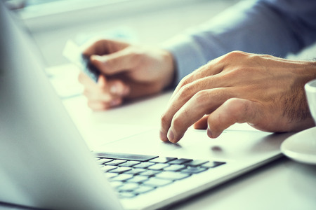Businessman holding credit card and typing on laptop for online shopping and payment makes a...