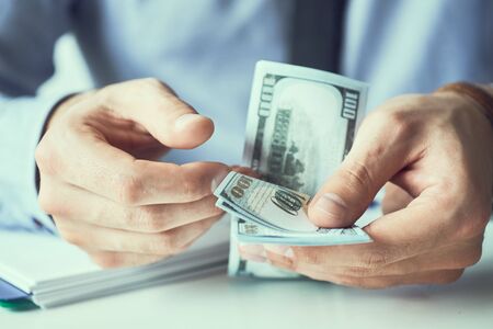 Businessman count the new us dollars paper money. Form of a bribe or salary.の写真素材