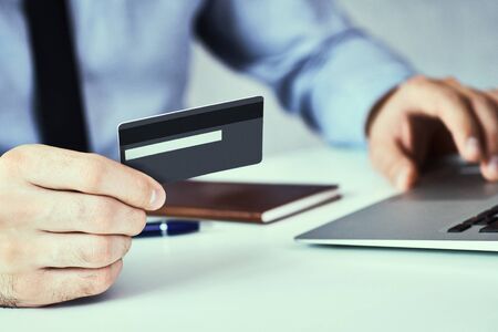 Businessman holding credit card and typing on laptop for online shopping and payment makes a purchase on the Internet close-up.の写真素材