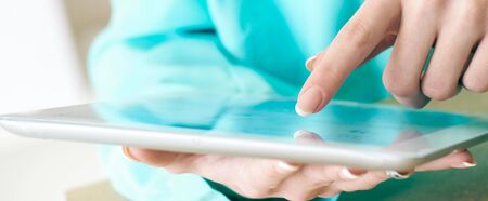 Female hands working with tablet computer close-up. Woman using social network, texting and...