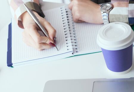 Top view of business woman hands making notes with silver pen in office background. Business finance savings loan and credit concept.の写真素材