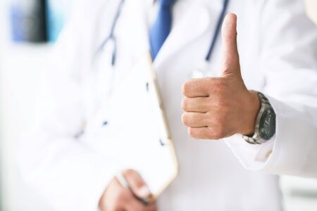 Close up of male doctor showing thumbs up gesture. Health care, people and medicine concept. Operation completed successfullyの写真素材