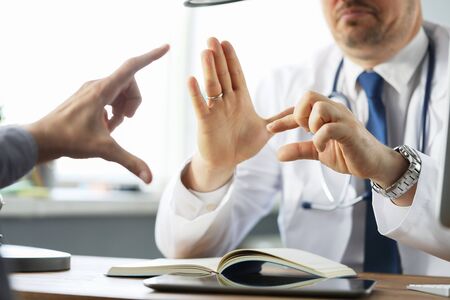 Male doctor shows by hands the number of side effects when taking the drug. Medical exam in doctors hospital office.の写真素材