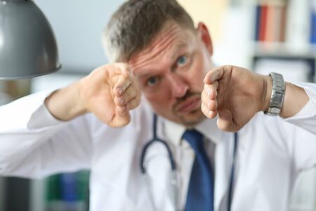 Male surgeon explains the features of cavity heart surgery to patient. Doctor and patient discussing.の写真素材