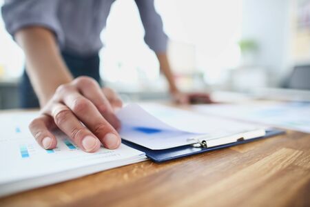 Close up of young businessman holding paper with financial information