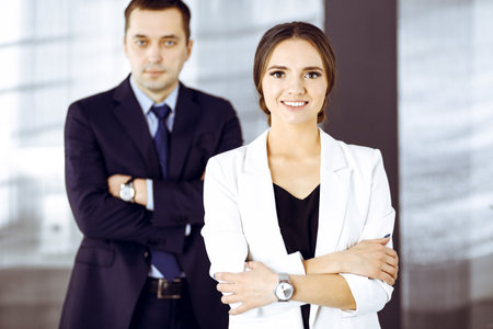 Confident business people are standing together with crossed arms in an office at meeting. Concept of success in a businessの写真素材