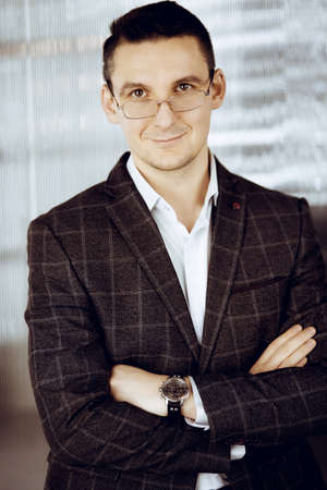 Friendly adult businessman in grey jacket. Business headshot or portrait in sunny officeの写真素材