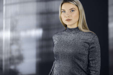 Young blonde business woman or female student standing straight and posing at camera. Lifestyle conceptの写真素材