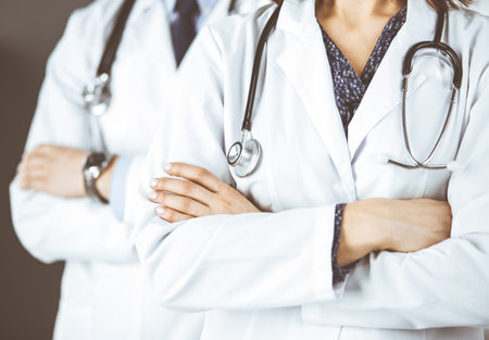 Group of modern doctors standing as a team with arms crossed in hospital office and ready to help patients. Medical help, insurance in health care, best disease treatment and medicine conceptの写真素材