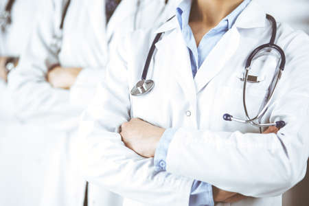 Group of modern doctors standing as a team with arms crossed in hospital office and ready to help patients. Medical help, insurance in health care, best disease treatment and medicine conceptの写真素材