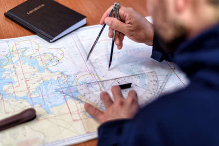 navigation with sea charts in the chart room on a sailing yachtの写真素材