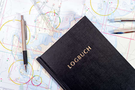 navigation book with sea charts in the chart room on a sailing yachtの写真素材